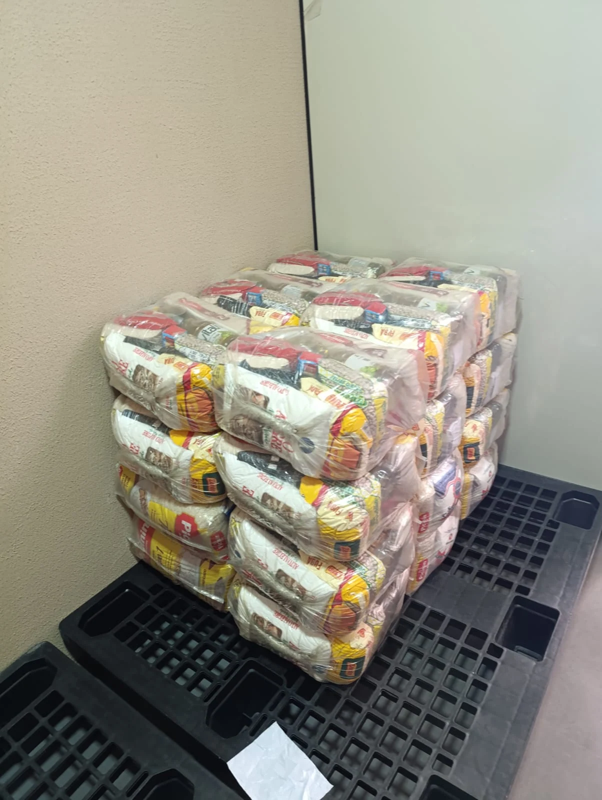 Foto real de várias cestas básicas Boa Mesa organizadas para entrega